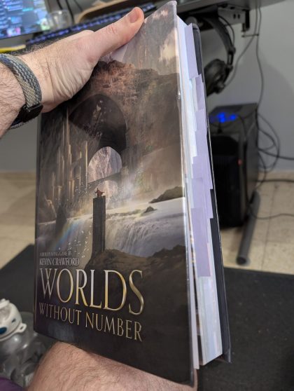 The tabletop roleplaying game book "WORLDS WITHOUT NUMBER" by Kevin Crawford. The book has a fantasy cover featuring ancient ruins with stone arches, a waterfall, and a small figure standing on a pillar. The edge of the book shows tabbed dividers.